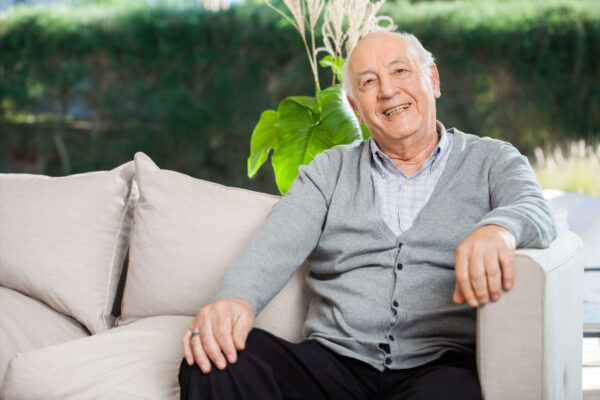 Smiling elderly man sitting on couch