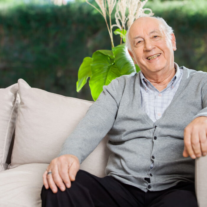 Smiling elderly man sitting on couch
