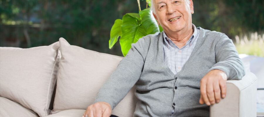 Smiling elderly man sitting on couch
