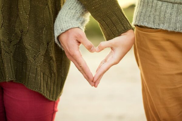 Couple forming heart shape with hands