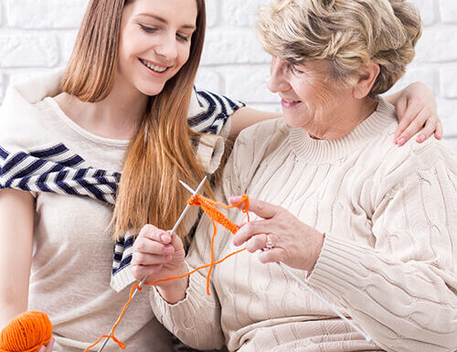 Young woman and elderly woman knitting together